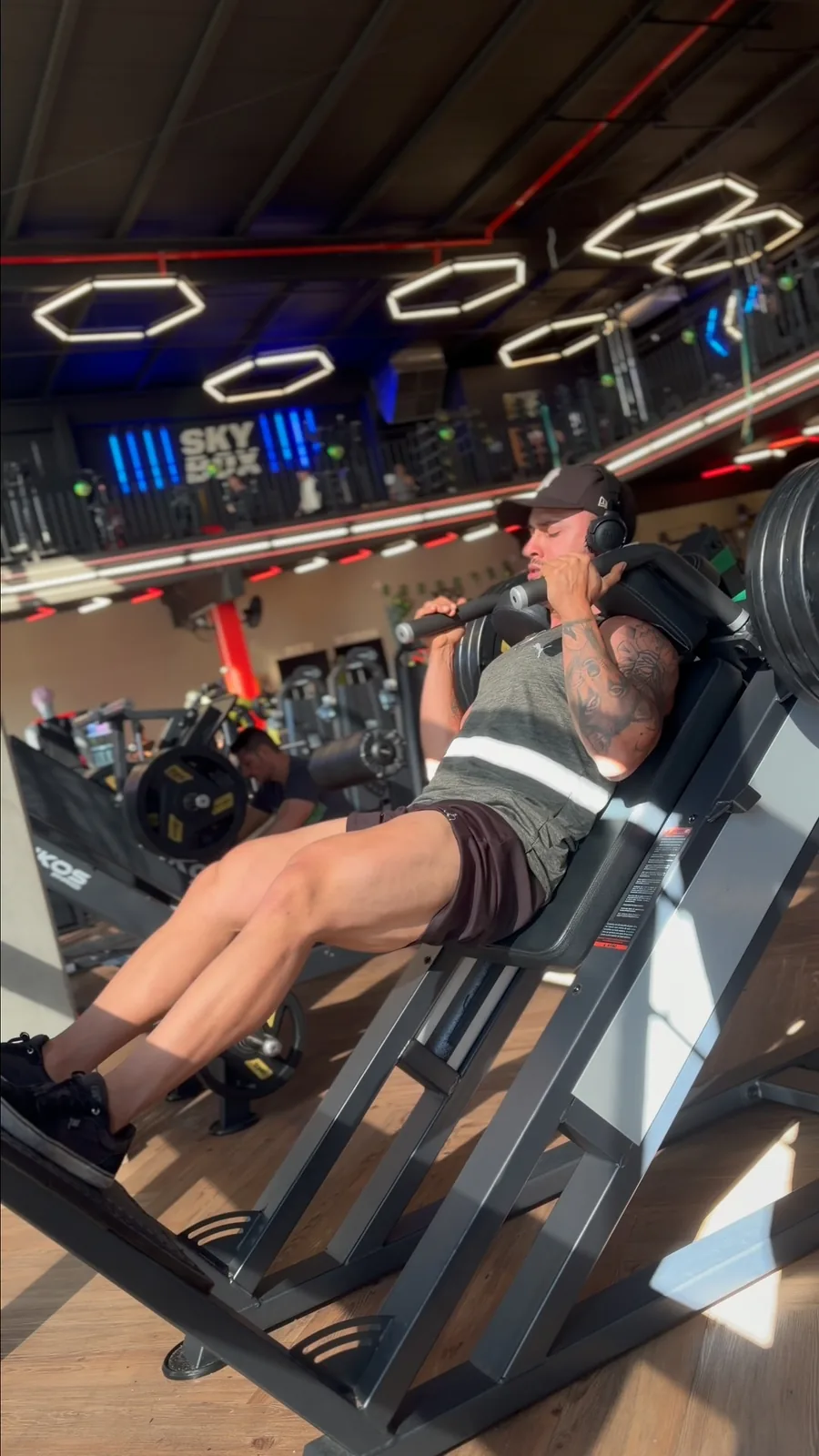 Matheus Torres executando um exercício de pernas na academia